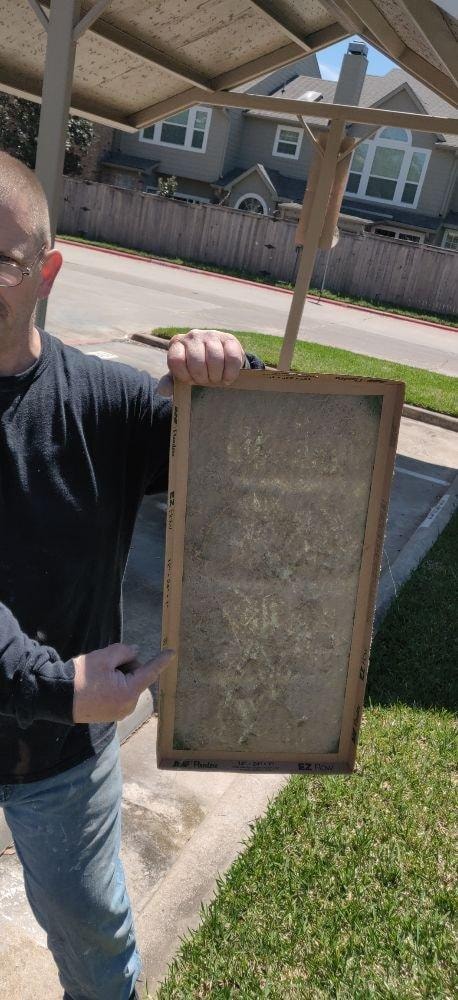 Person holding a dirty air filter